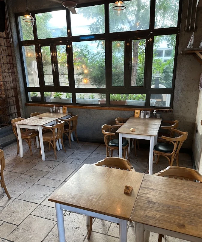 Cozy dining area at Mamaesh Al Manara, Dubai with wooden tables.