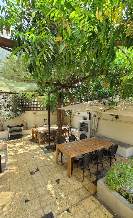 Outdoor seating area at Mamaesh Al Manara, Dubai, with wooden tables.