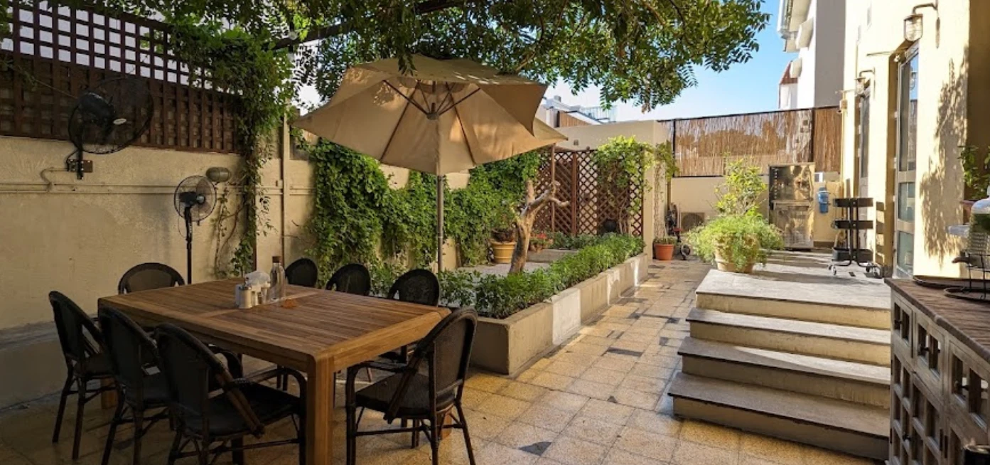 Outdoor dining area at Mamaesh Al Manara, Dubai with greenery.