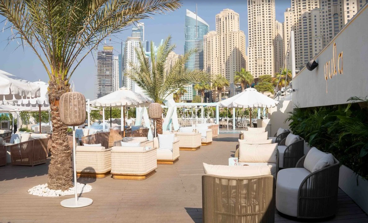 Yula Lounge outdoor seating with Dubai skyline in background.