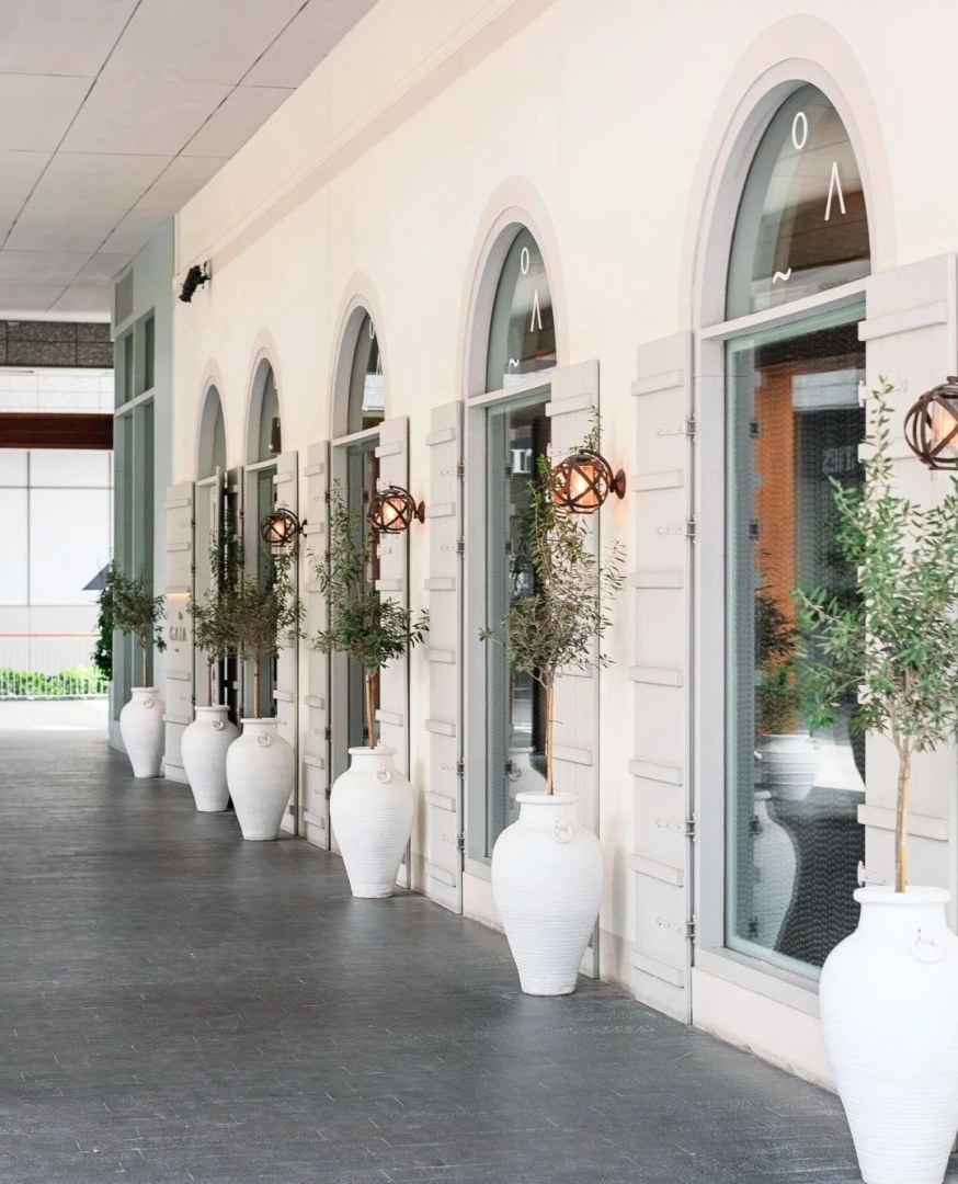 Gaia Dubai exterior with arched windows and white planters.
