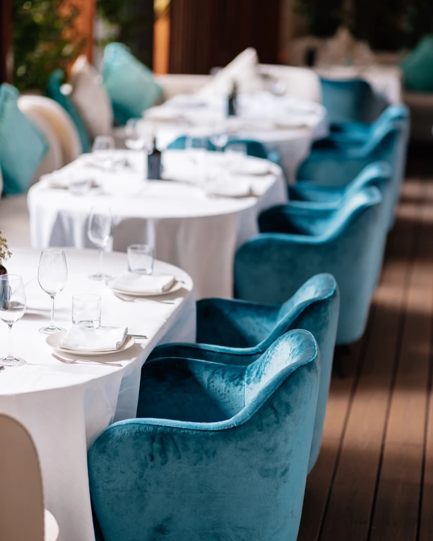 Elegant dining setup with blue chairs at Gaia Dubai restaurant.