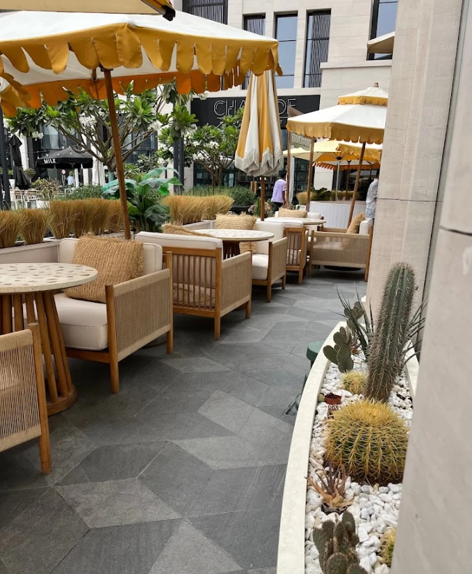 Outdoor seating at Brunch & Cake Wasl 51, Dubai with umbrellas.