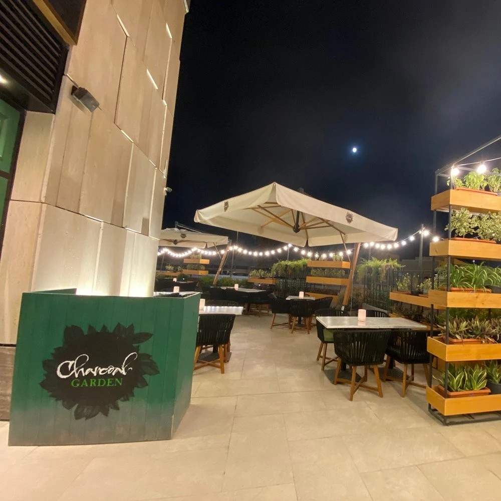 Charcoal Garden Restaurant outdoor seating, Dubai Media City, night ambiance.