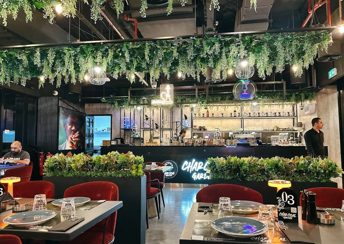 Charcoal Garden Restaurant Dubai, lush greenery, modern decor, dining tables.