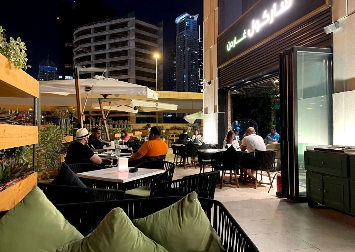 Outdoor dining at Charcoal Garden Restaurant, Dubai Media City, nighttime ambiance.
