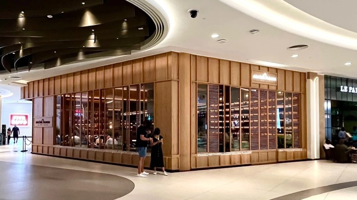 Social House Restaurant Dubai exterior with wooden facade and large windows.