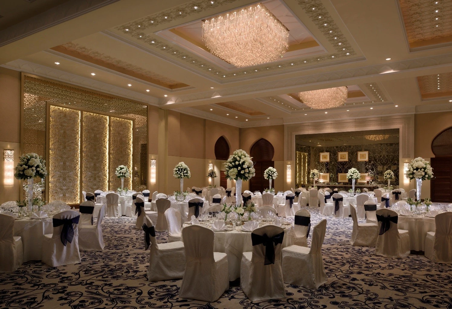 Luxurious ballroom with floral centerpieces at One&Only Royal Mirage, Dubai.