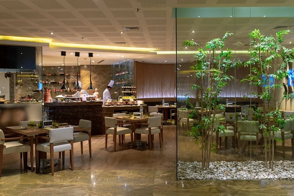 Elegant interior of Kitchen 6 Restaurant Dubai with chef and tables.