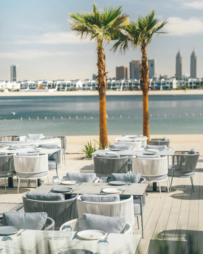Outdoor dining at Bebabel The Palm Restaurant, Dubai with waterfront view.