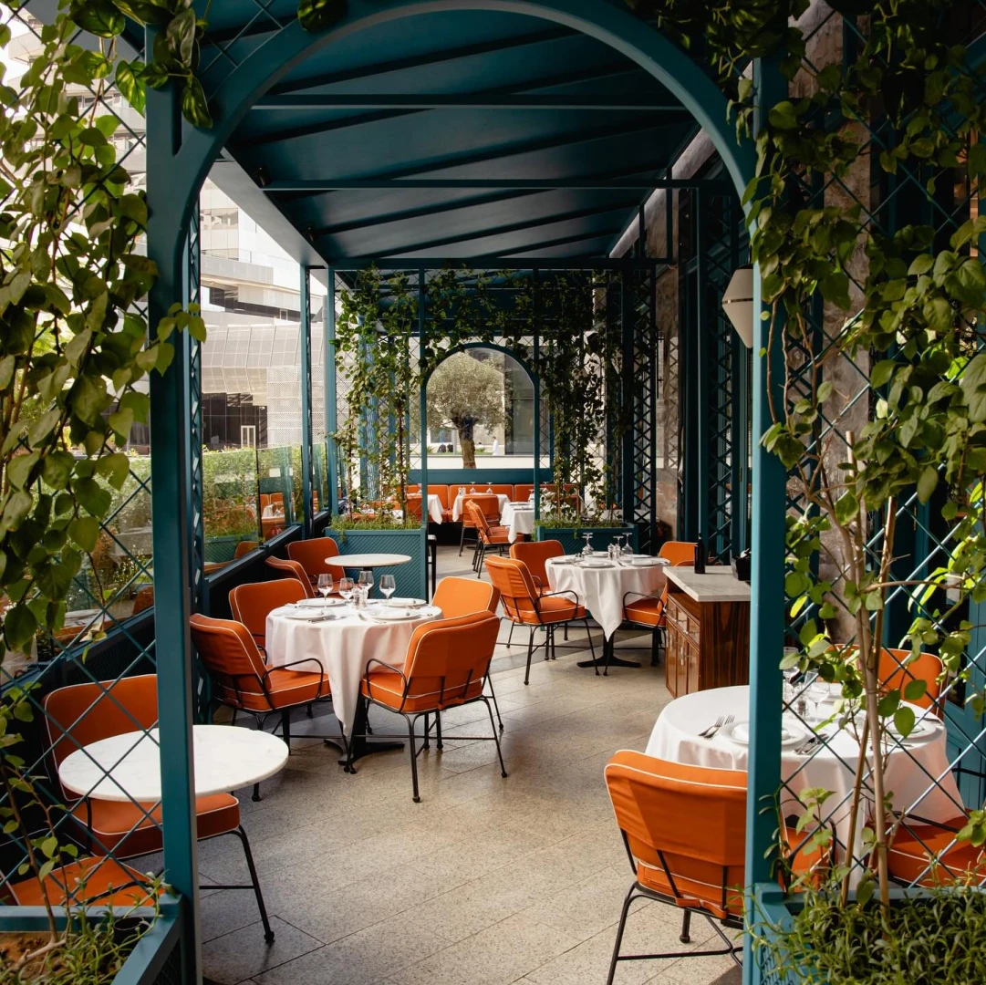 Il Baretto Riyadh terrace with greenery and orange seating.