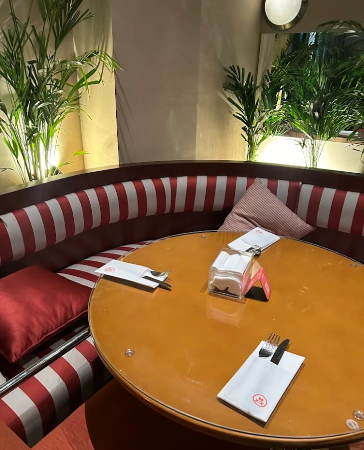 Cozy booth with striped seating at PUBLIC Restaurant Riyadh As Sulimaniyah.