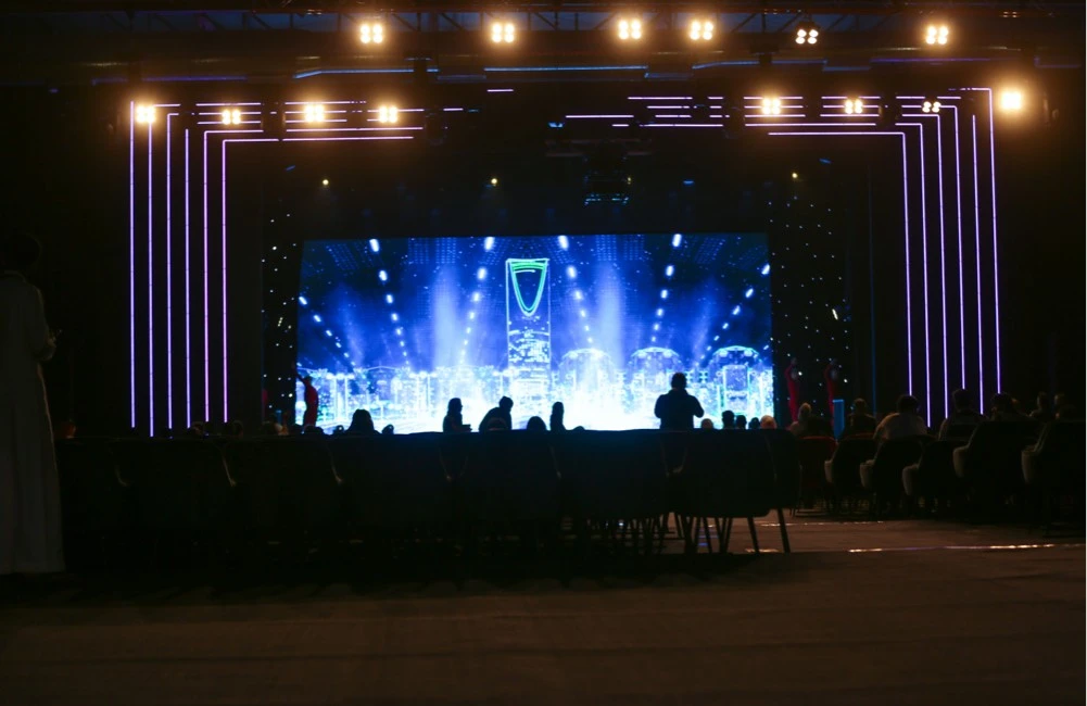 Riyadh Front Exhibition Center stage with illuminated cityscape backdrop.