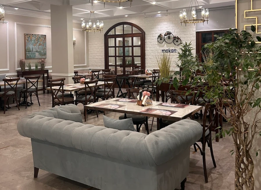 Elegant dining area at Makan Indian Restaurant, Jeddah with chandeliers.
