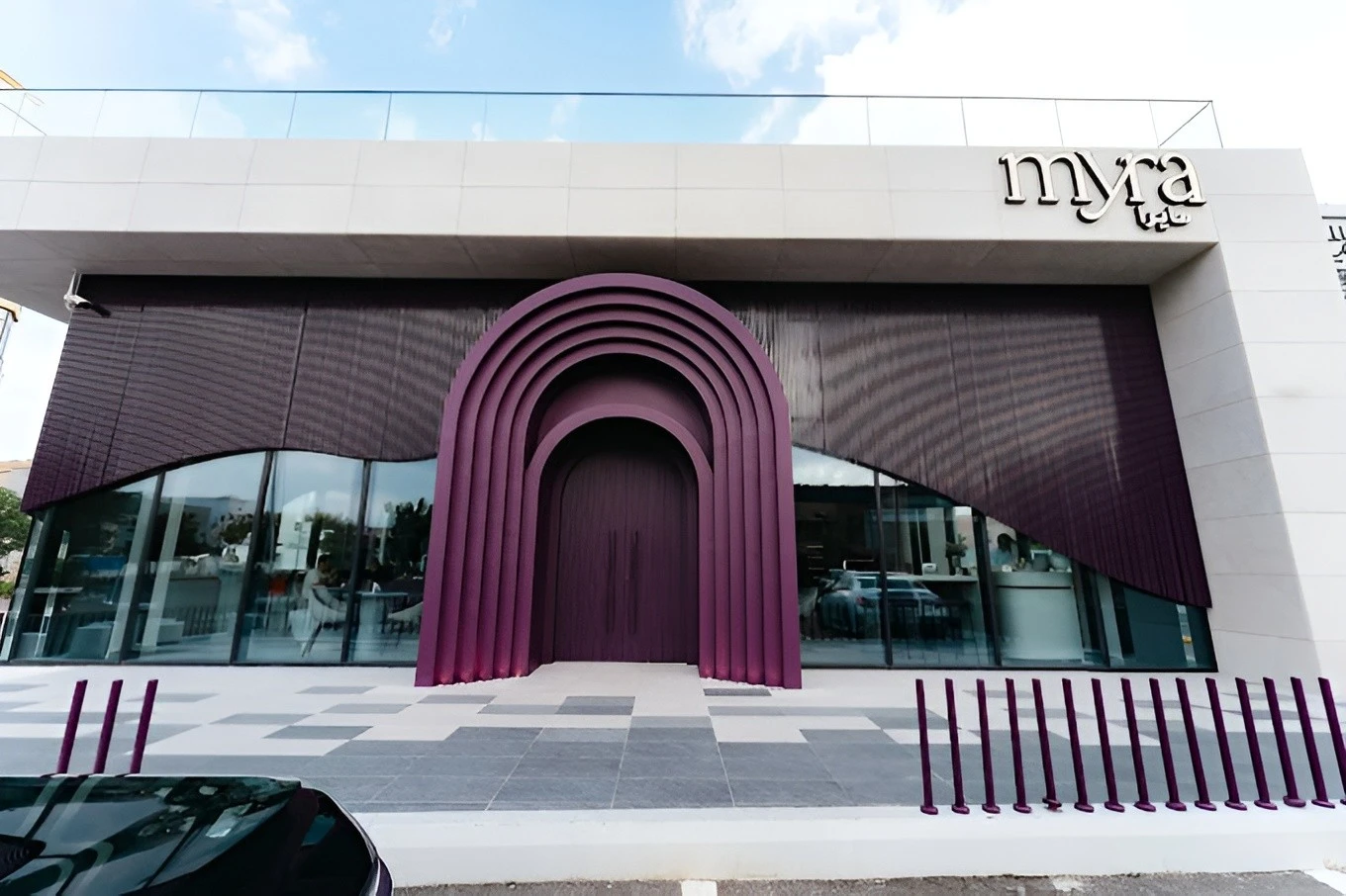 Modern purple entrance of Myra Cafe Jeddah with glass windows.