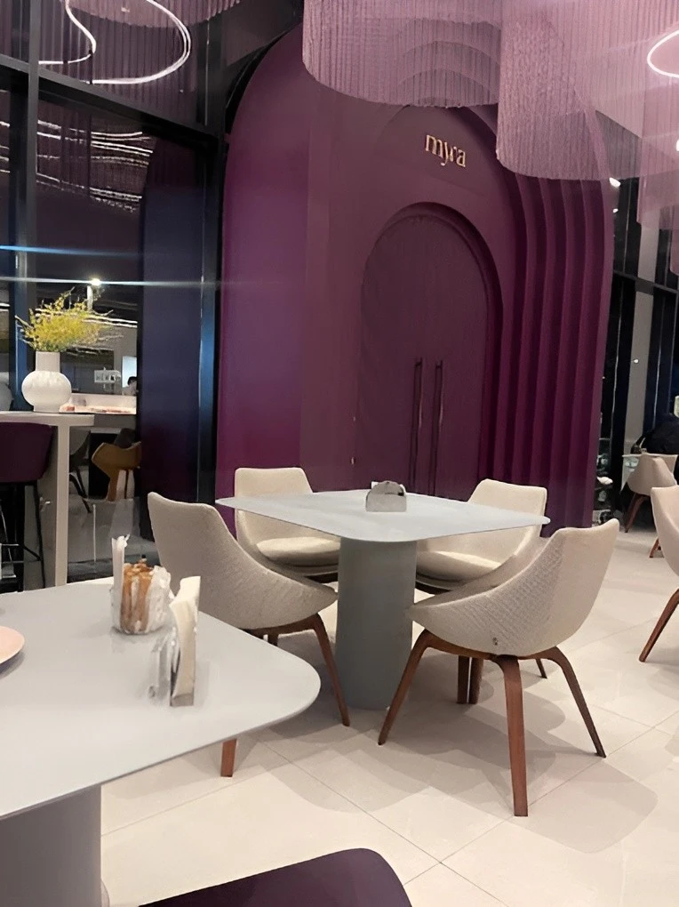 Modern interior of Myra Cafe Jeddah with purple accents and seating.