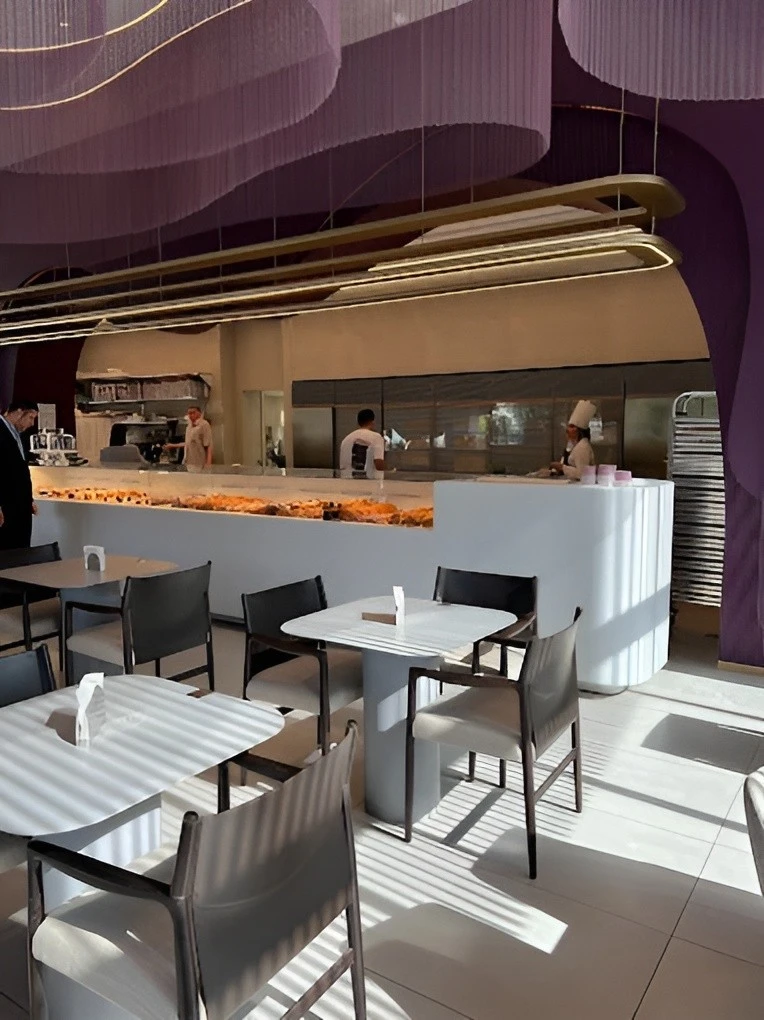 Modern interior of Myra Cafe Jeddah with tables and staff.