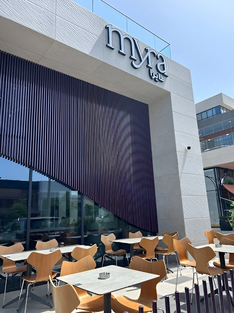 Outdoor seating at Myra Cafe Jeddah with modern decor.