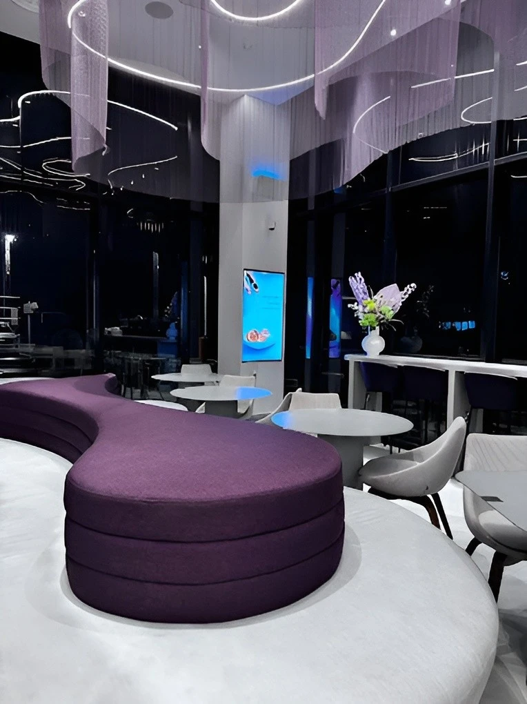 Modern interior of Myra Cafe Jeddah with purple seating.