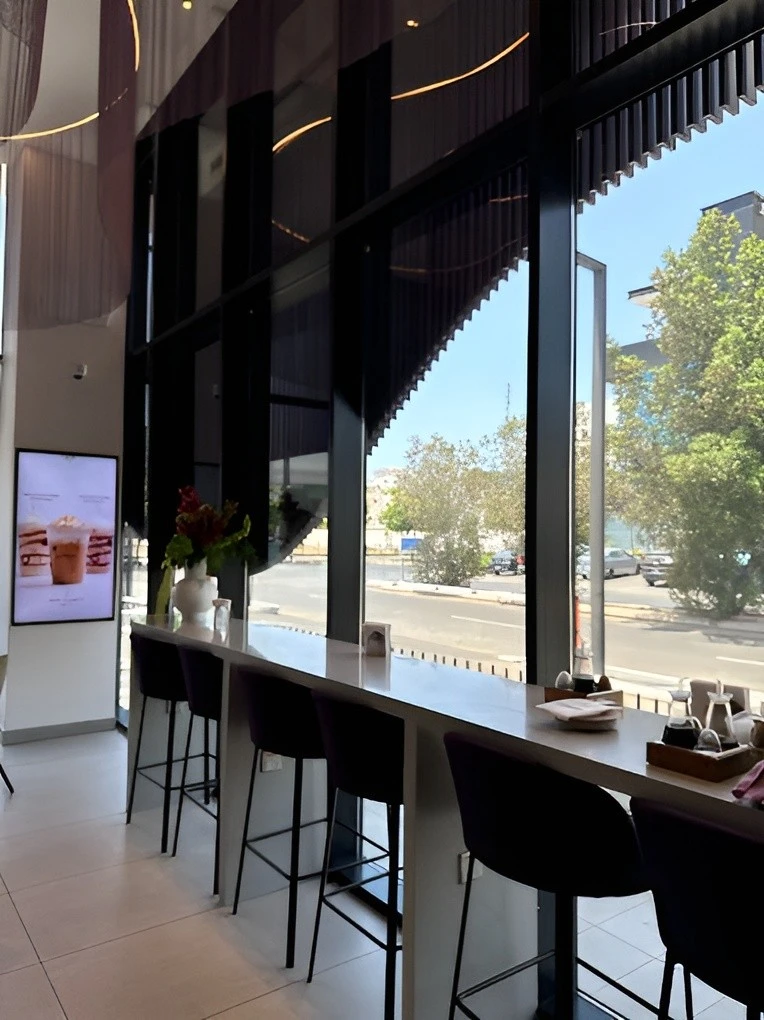 Modern interior of Myra Cafe Jeddah with street view.