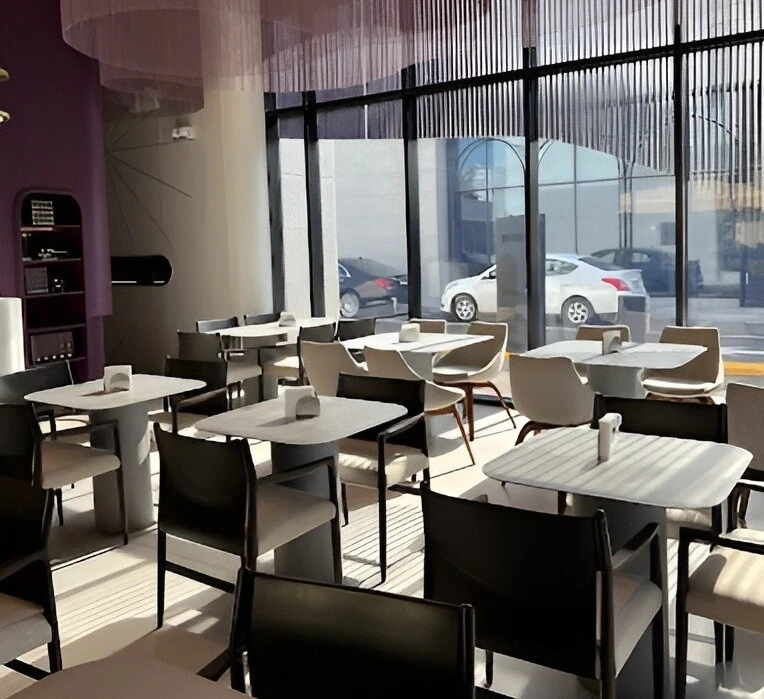 Modern interior of Myra Cafe Jeddah with tables and chairs.