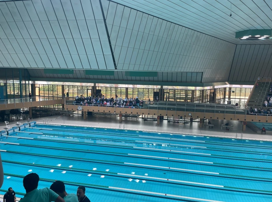 Spectators overlooking indoor pool at Jeddah's sports city venue.