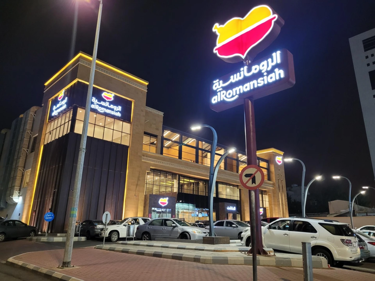 Al Romansiah Restaurant Makkah exterior at night with parked cars.