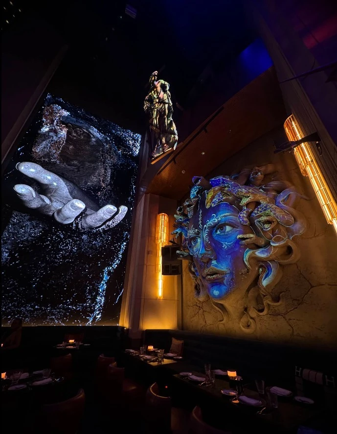 Zenon Restaurant Dubai interior with artistic wall sculptures and lighting.