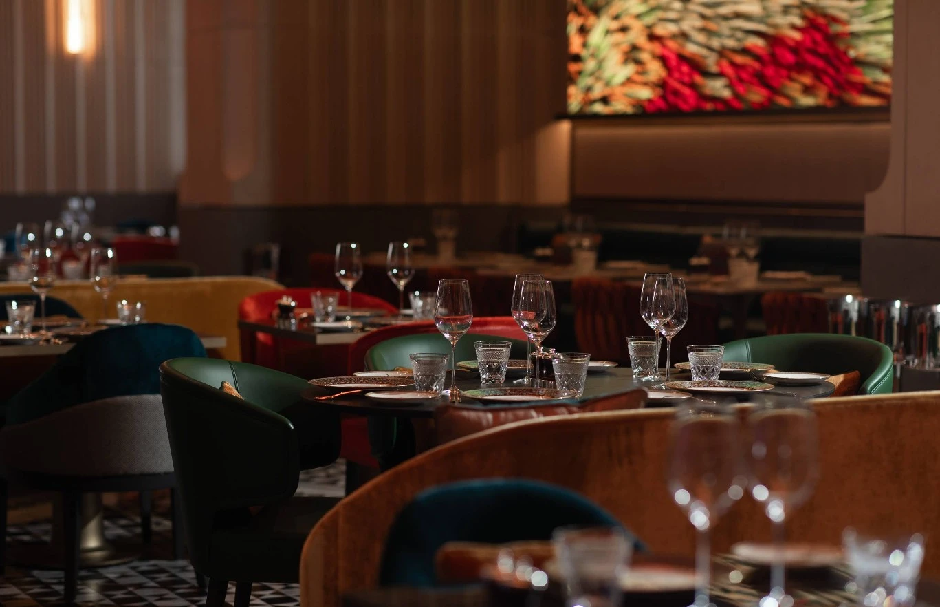 Elegant dining setup at Zenon Restaurant Dubai with colorful chairs.