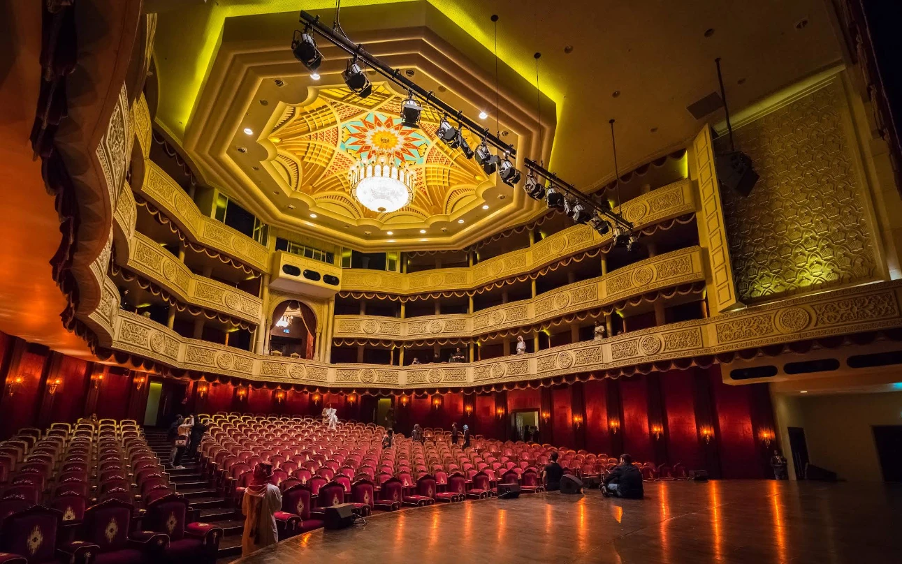 Interior of Katara Opera House, Doha, featuring ornate balconies and chandelier.