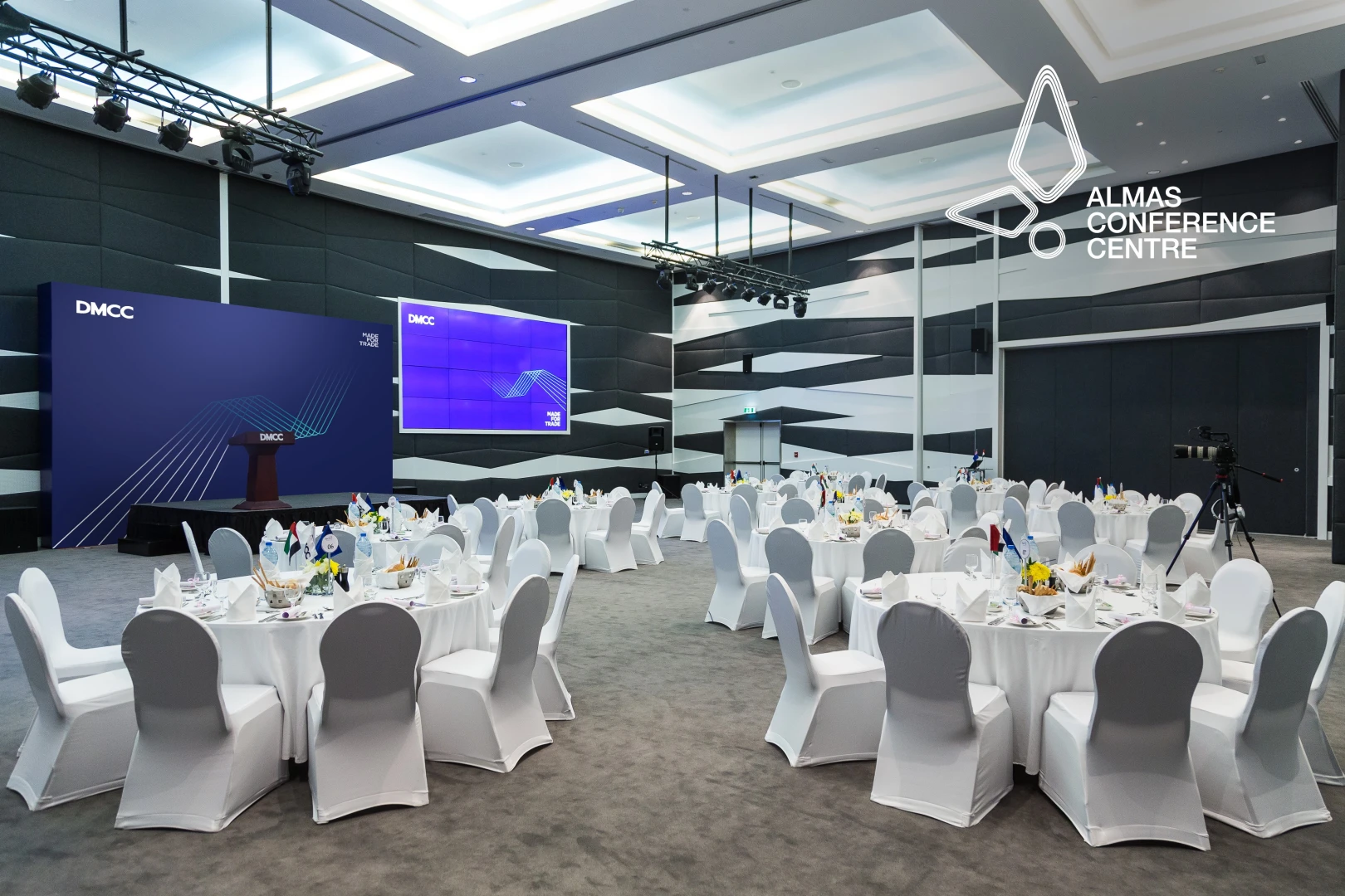 Almas Conference Centre Dubai, elegant setup with round tables and stage.