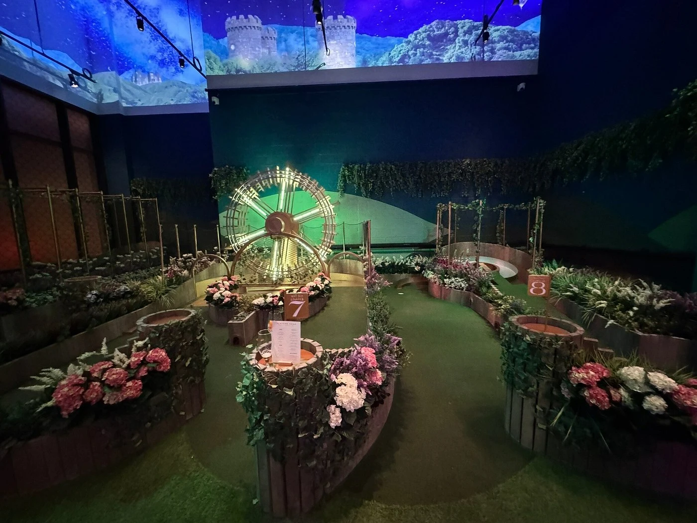 Indoor mini-golf course with colorful flowers, Swingers Dubai.