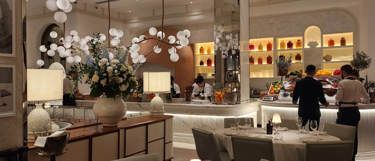 Elegant interior of Gaia Restaurant Doha with floral centerpiece and lighting.