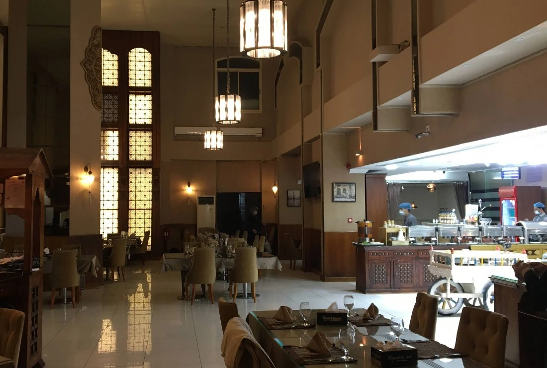 Warmly lit dining area with decorative windows at Nayaab Haandi, Dubai.