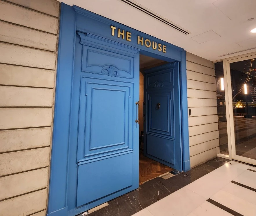 Blue entrance door of The House Restaurant Lusail.