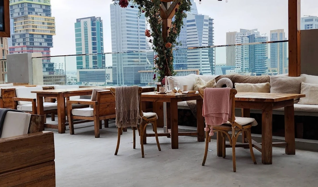 Cozy outdoor seating at The House Restaurant Lusail with city view.