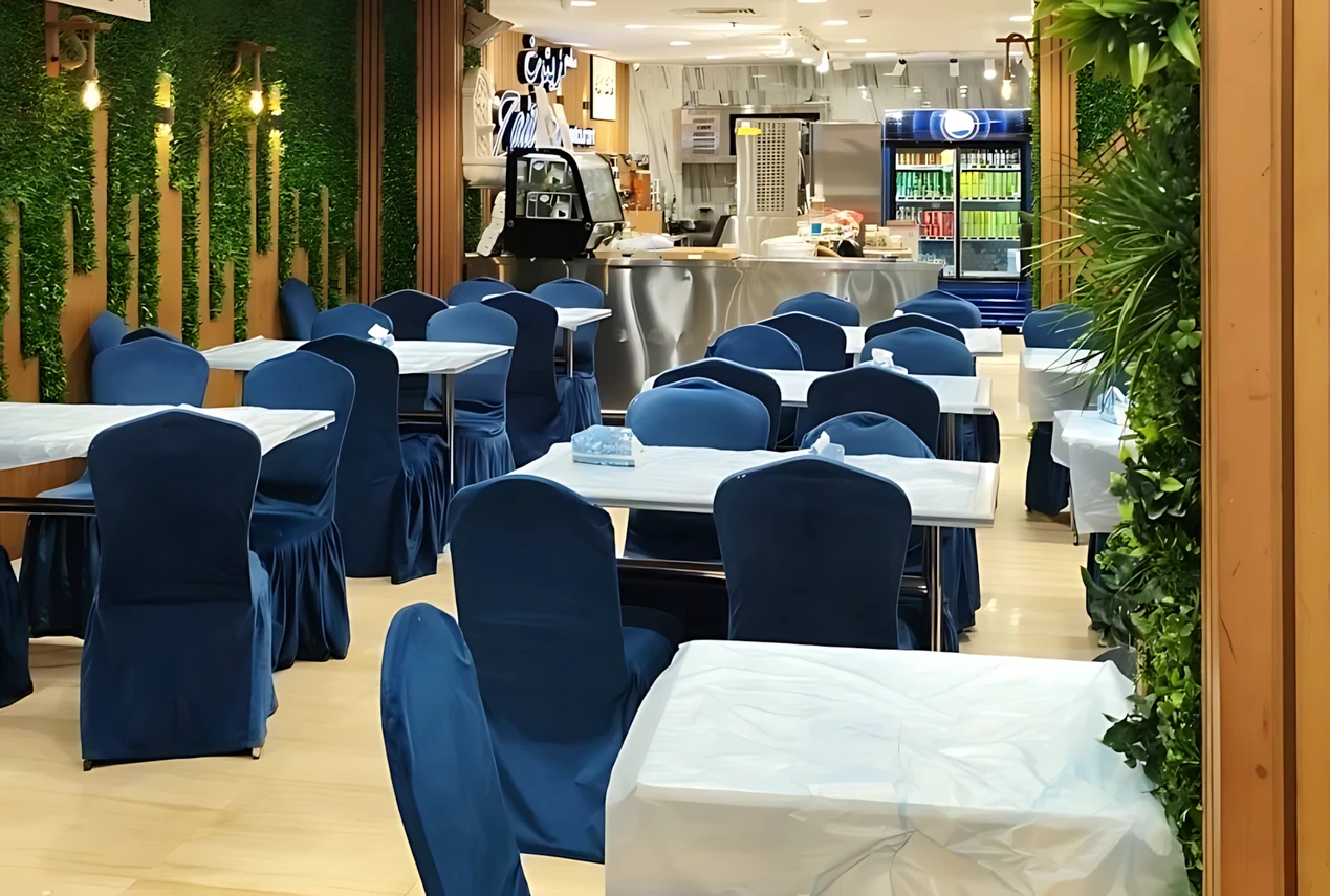 Zaitoon Restaurant Madinah with blue seating and vibrant greenery.