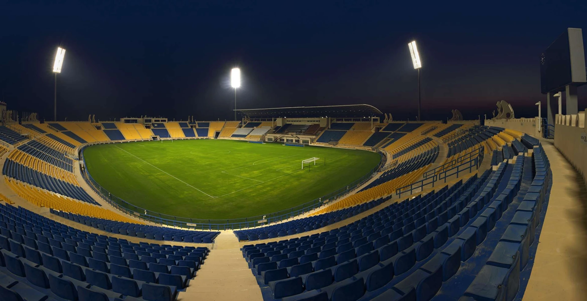 Thani Bin Jassim Stadium at night, Al Rayyan, empty seats visible.