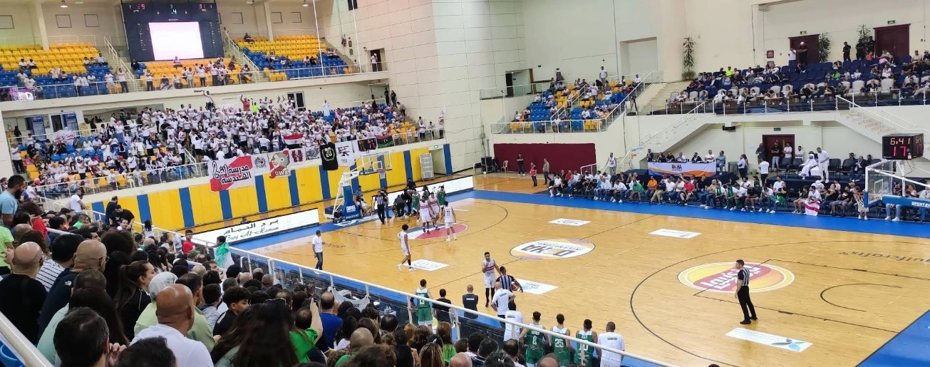 Basketball game at Thani Bin Jassim Stadium, Al Rayyan, crowded stands.
