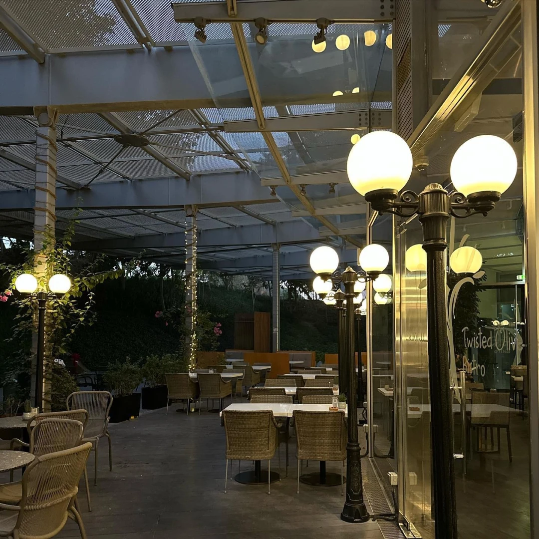 Outdoor seating at Twisted Olive & Naama’s Garden, Doha, with lampposts.