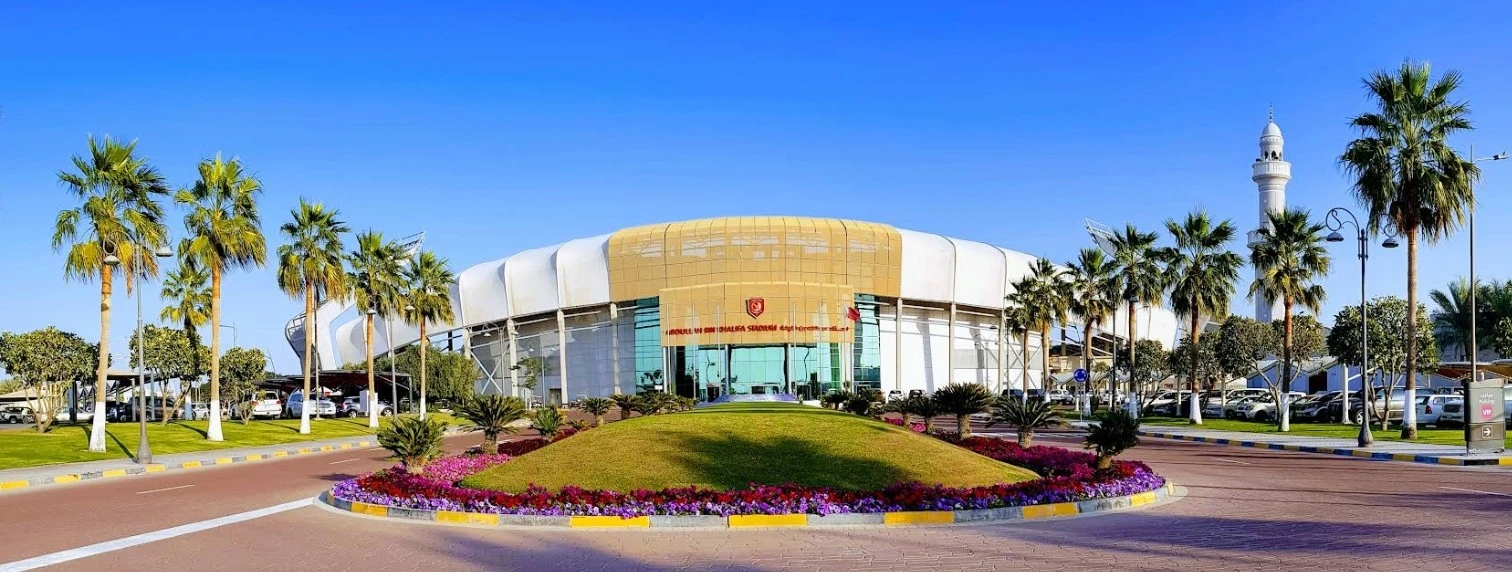 Abdullah Bin Khalifa Stadium entrance with palm trees, Doha.