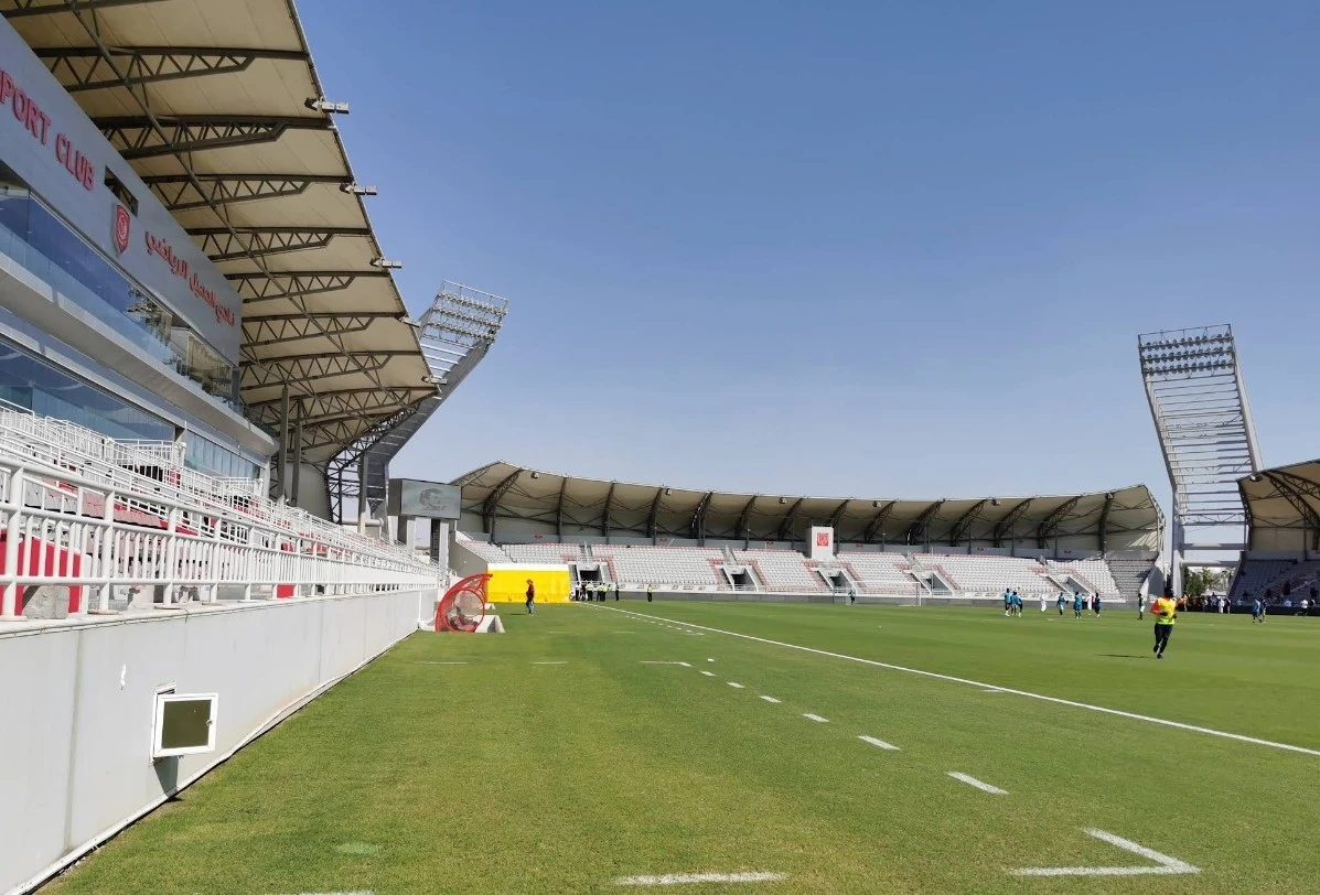 Abdullah Bin Khalifa Stadium in Doha, empty stands and green field.