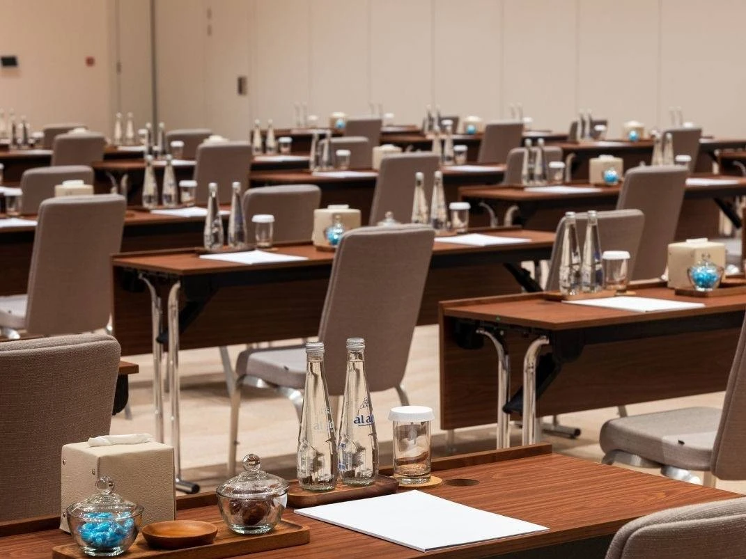 Conference room setup at Erth Hotel Abu Dhabi with tables and chairs.