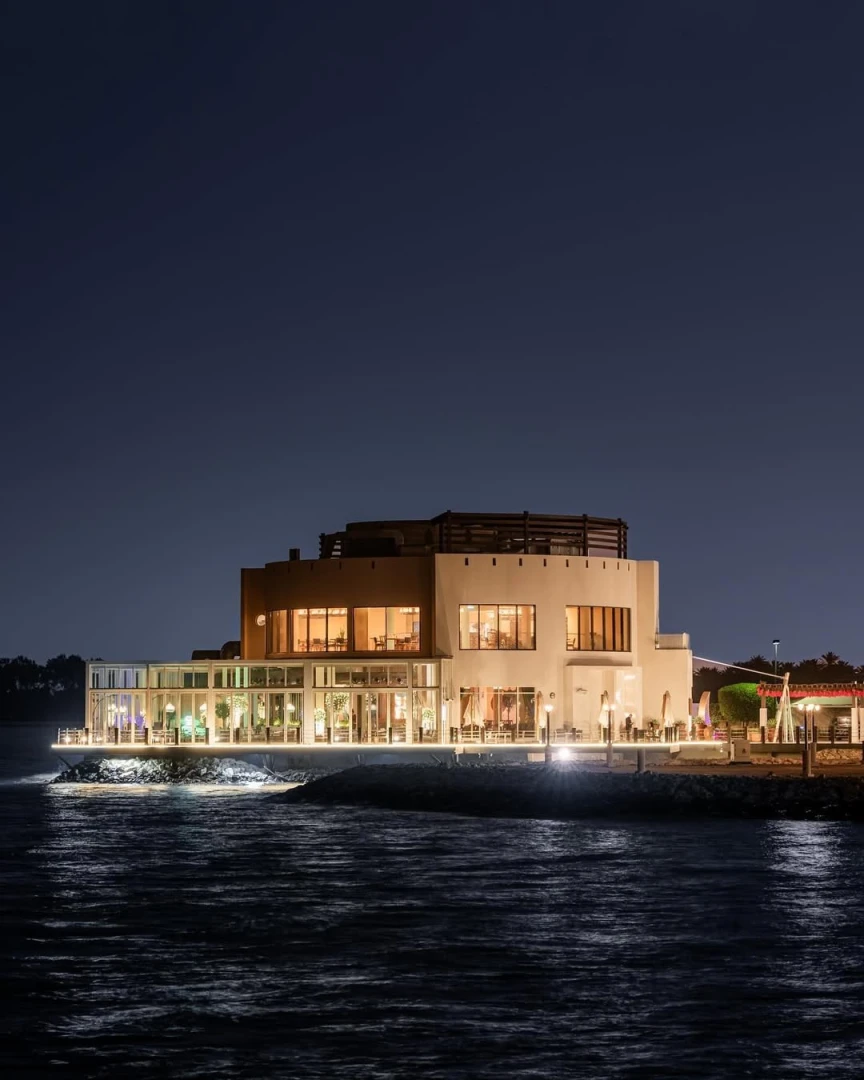 Yamaz Restaurant Bahrain illuminated at night, waterfront view in Manama.