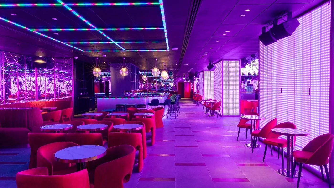Vibrant lounge with purple lighting at Voco Monaco Dubai by IHG.
