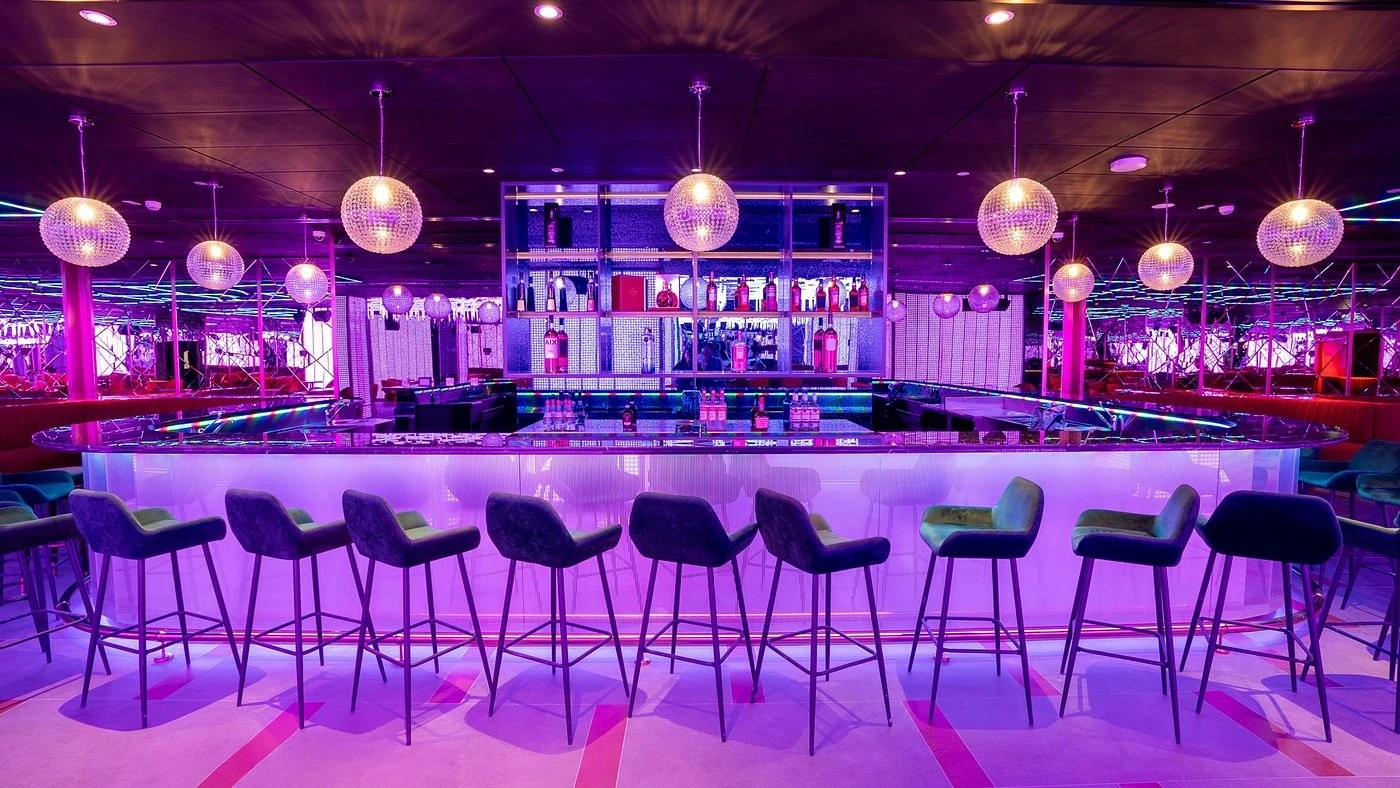 Vibrant bar interior at Voco Monaco Dubai, featuring modern lighting.