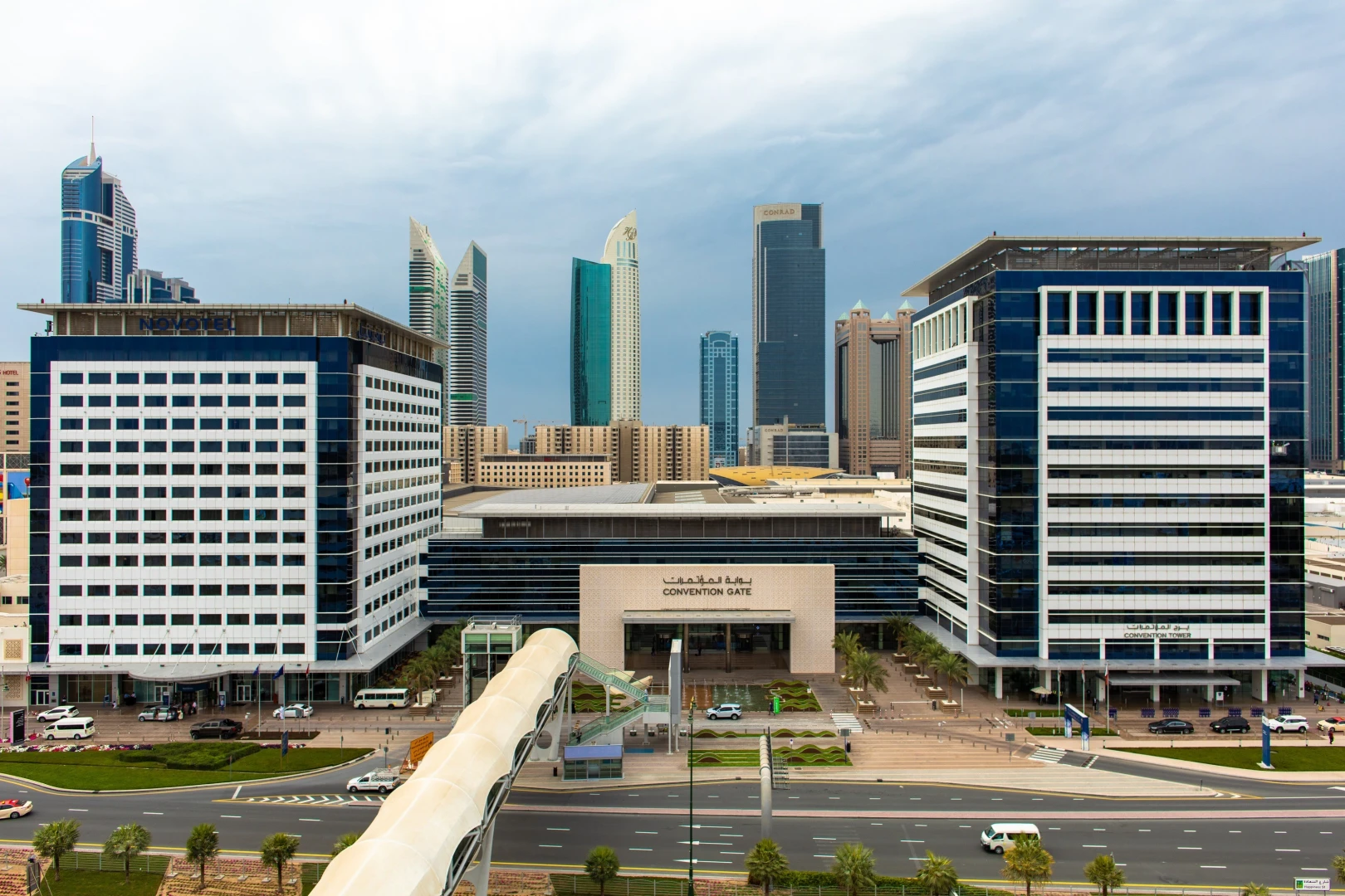Sheikh Rashid Hall entrance, Dubai skyline in background.