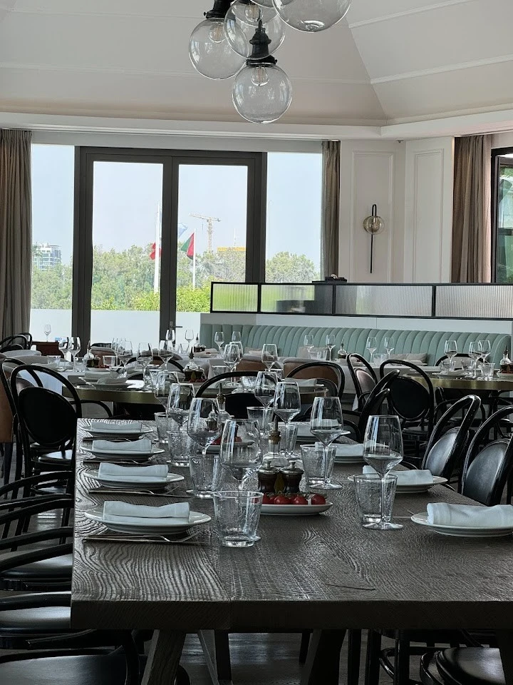 Elegant dining setup at Carine Restaurant, Dubai with large windows.