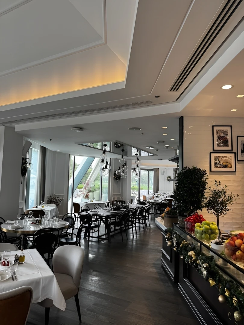 Elegant dining area at Carine Restaurant Dubai with large windows.