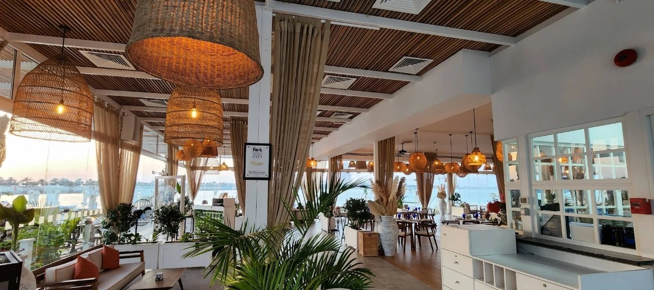 West Bay Lounge Abu Dhabi interior with wicker lights and plants.